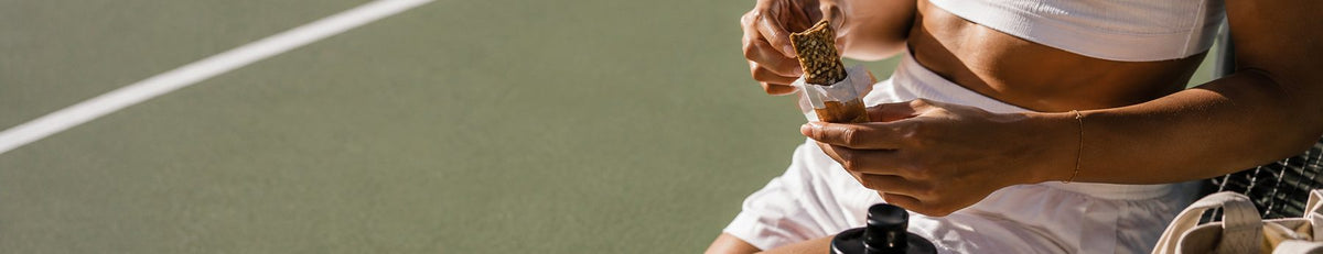 Tenis kortunda mola veren sporcu, elinde bar